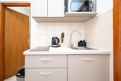 a kitchen with white cabinets and a sink at Studio Zubovici 9365a in Zubovići