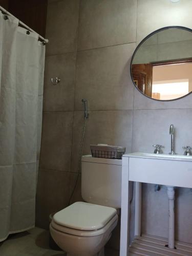 a bathroom with a toilet and a sink and a mirror at Casa Florencia in Cachí