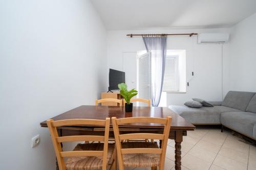 a dining room table with chairs and a couch at Apartments with swimming pool Zubovici, Pag - 9365 in Zubovići