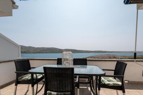 a table and chairs on a balcony with a view of the water at Apartment Zubovici 9365b in Zubovići