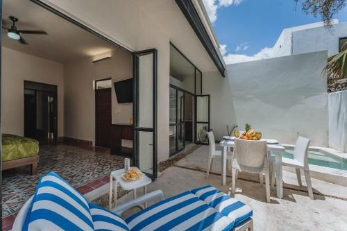 a patio with a table and chairs and a pool at Casa Tropical in Mérida