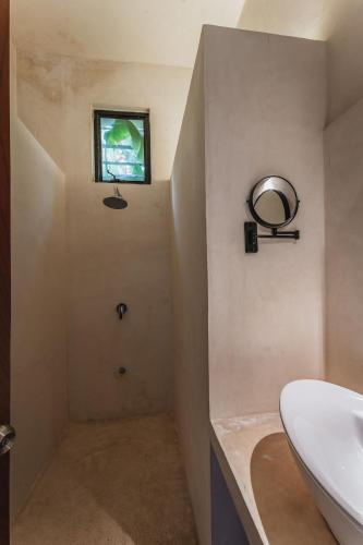 a bathroom with a sink and a mirror and a window at Casa Tropical in Mérida