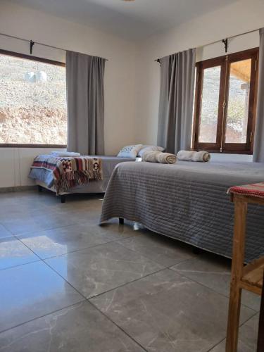 a bedroom with two beds and a large window at Casa Florencia in Cachí