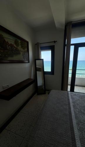 a bedroom with a mirror and a view of the ocean at Star beach in M'diq