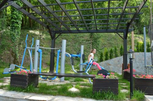 a woman is riding on a bike on a playground at Park Hotel Asenevtsi in Veliko Tŭrnovo