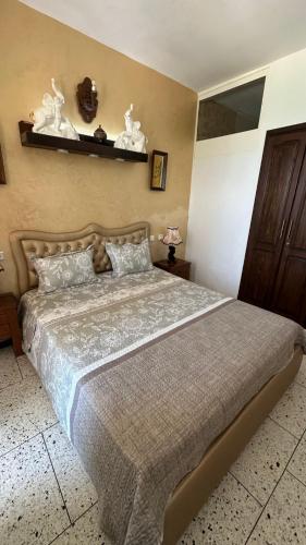 a bedroom with a large bed and a shelf on the wall at Star beach in M'diq