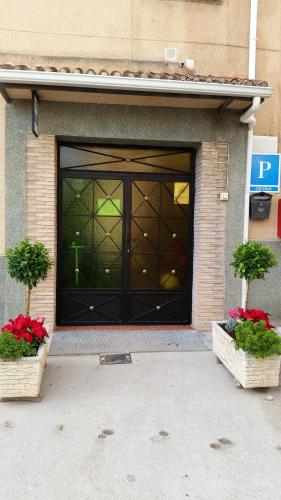 a front door of a building with two potted plants at Hidalgo in Alcaudete