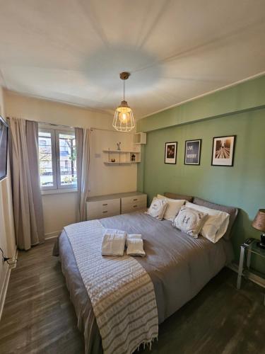 a bedroom with a large bed with two towels on it at Cozy Vibes Apartment Tucumán in San Miguel de Tucumán