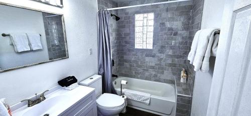 a white bathroom with a sink and a toilet at 3Bd, King, Brkfst, Large TVs, WD, Sleeps 11, BBQ in Page