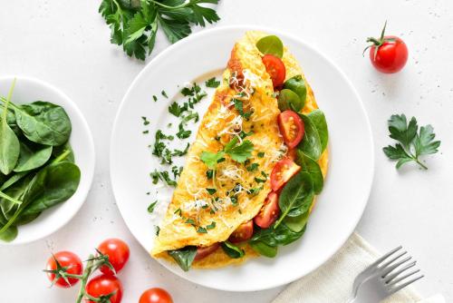a white plate with a omelet with tomatoes and vegetables at Holiday Inn New York City - Wall Street by IHG in New York