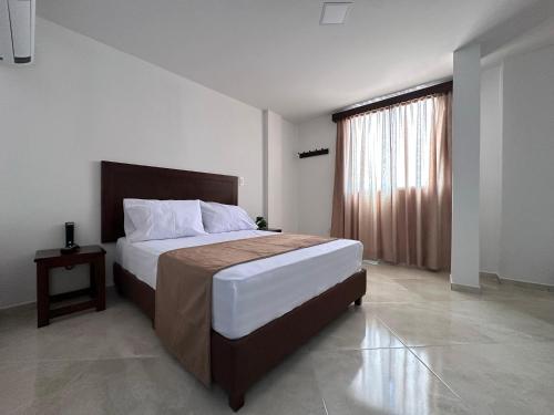 a bedroom with a large bed and a window at Santa Elena Hotel in Ocaña