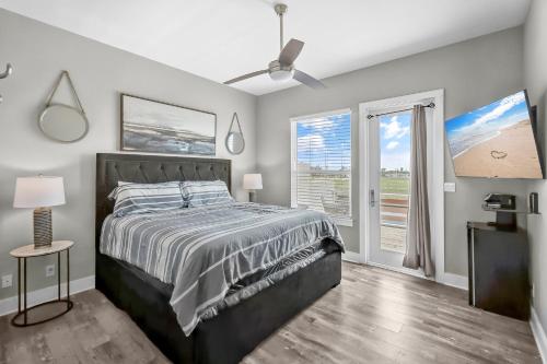 a bedroom with a bed and a large window at Waterfront Condo with Rooftop + Pool + Boat Slips in Corpus Christi