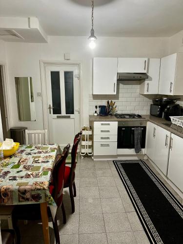 a kitchen with a table and a kitchen with white cabinets at Lucifer in London