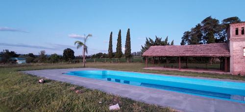 einem Pool vor einem Gebäude mit einem Pavillon in der Unterkunft Finca La Encantada in San Miguel de Tucumán