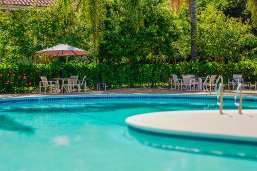 a swimming pool with chairs and an umbrella at Uptown Oasis San Jose Airport & Silicon Valley in San Jose