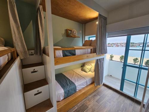 Schlafzimmer mit Etagenbetten und Meerblick in der Unterkunft Adra Hostal Peten in Flores