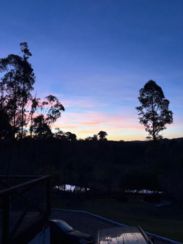a view of a sunset with trees in the background at Suite Lua Crescente in Caldas