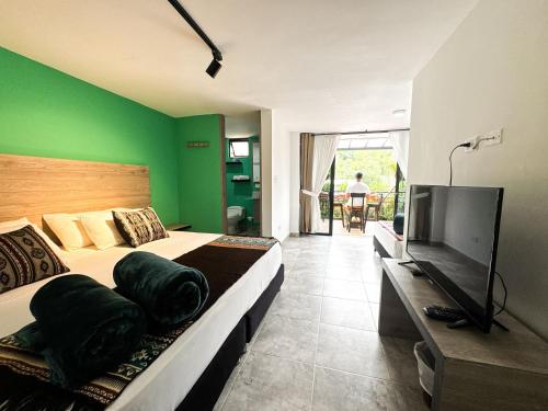 a bedroom with two beds and a flat screen tv at Tierra Maravilla in Salento