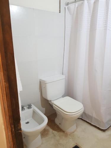 a white bathroom with a toilet and a sink at Casa en Tilcara - Espaciosa, equipada y lista para disfrutar in Tilcara