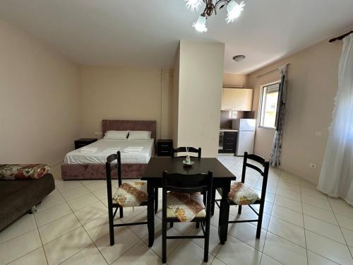een slaapkamer met een bed, een tafel en stoelen bij Brownie in Vlorë