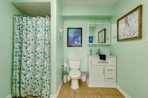Un baño con inodoro y cortina de ducha. en Tortuga Inn, en Galveston