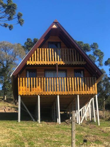 a large wooden house with a large deck at Hospedagem Família Cruz in Urubici