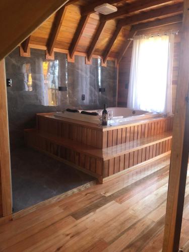 a large wooden bath tub in a room with a window at Hospedagem Família Cruz in Urubici