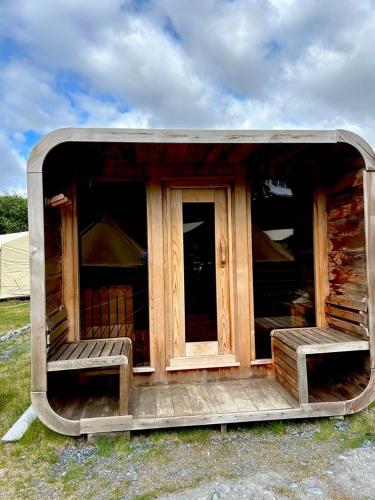 a small cabin with a door and two benches at Howling Wolf Resort in Seward