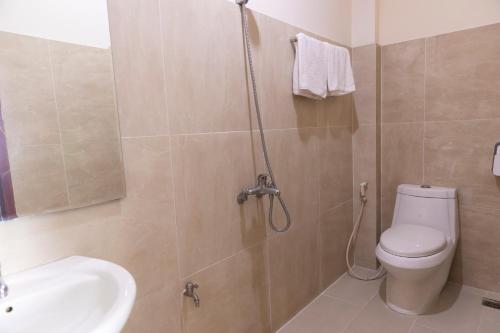 a bathroom with a shower with a toilet and a sink at Atana Airport Hotel in Ho Chi Minh City