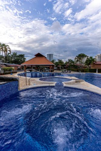 a swimming pool with blue water in a resort at Villas Paraiso B52 in Jacó