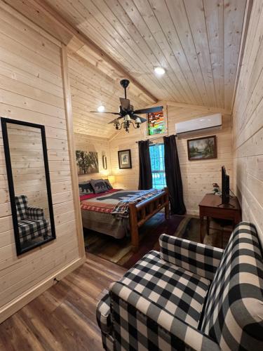 ein Schlafzimmer mit einem Bett und einer Couch in einem Zimmer in der Unterkunft The Dapper Duck Log Cabin in Cosby