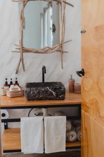 a bathroom with a sink and a mirror and towels at Toninas México Bungalow in Celestino Gasca