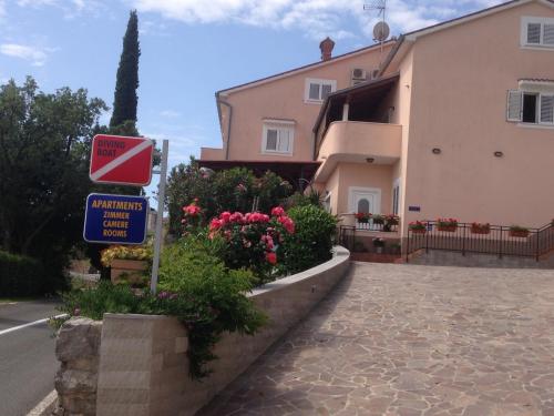 a street sign in front of a building with flowers at Apartments Vunić in Mošćenička Draga