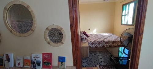 a mirror reflecting a bedroom with a bed in a room at DAIFLAH Guesthouse & Hostel 
