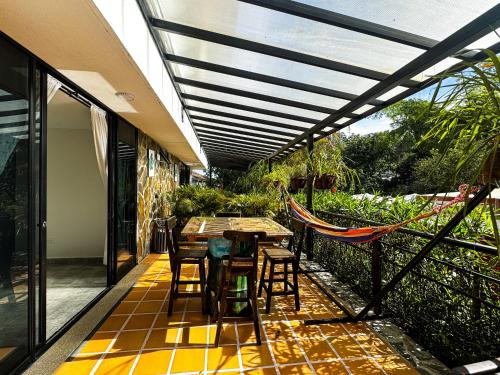 a patio with a table and chairs and a hammock at Tierra Maravilla in Salento
