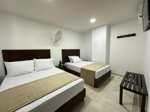 a hotel room with two beds and a table at Santa Elena Hotel in Ocaña