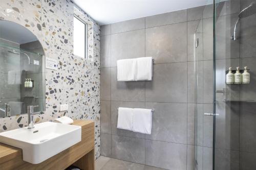 a bathroom with a sink and a shower at Nightcap at Queens Beach Hotel in Bowen