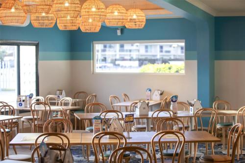 an empty dining room with tables and chairs at Nightcap at Queens Beach Hotel in Bowen