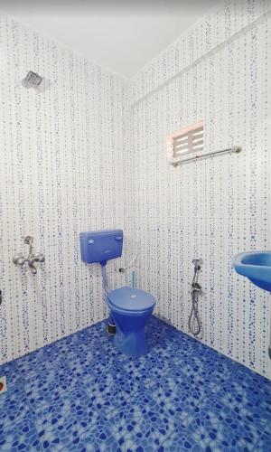 a bathroom with a blue toilet and a sink at Jacksons Beach House Calangute in Calangute