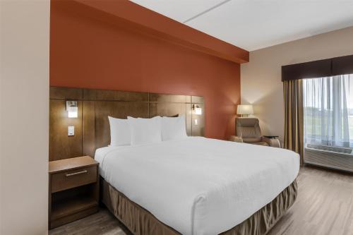a hotel room with a large bed and a window at Best Western Plus Winnipeg West in Winnipeg
