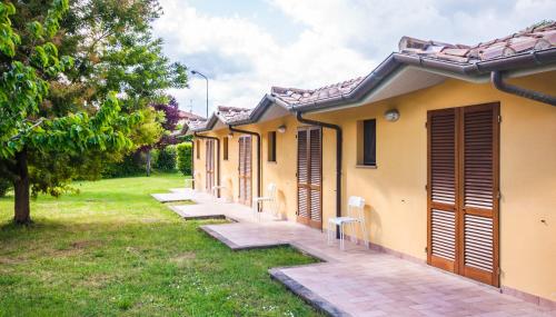 a row of cottages in a park with trees at Le Macerine in Castiglione del Lago