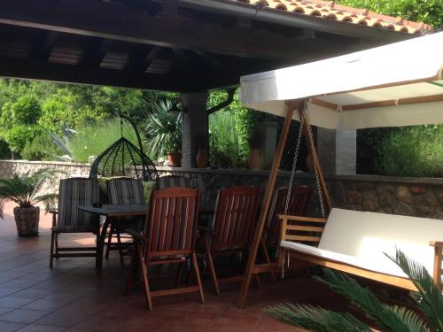 a patio with chairs and a table and an umbrella at Apartments Vunić in Mošćenička Draga