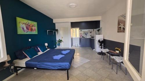 a bedroom with a bed and a blue wall at Celina's Cozy Studio & Beach Life in One in Santa Maria