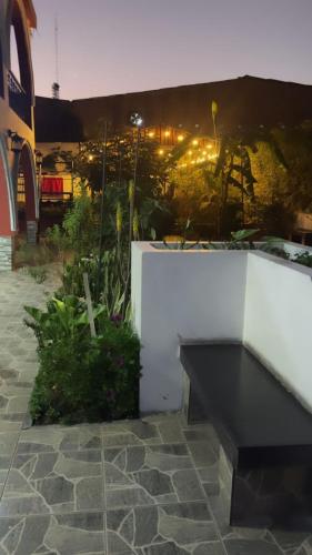 a black bench sitting next to a white wall at Casa Baraquel in Arequipa
