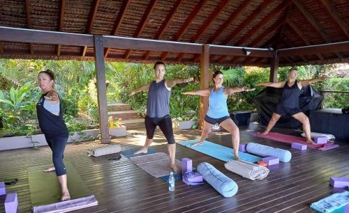 un grupo de personas en una clase de yoga en Karma Waters Villa, en Port-Havannah