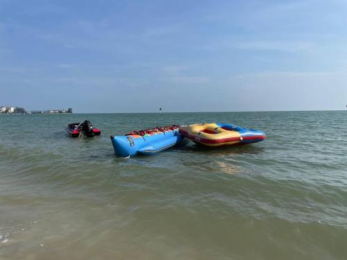 two inflatable boats in the water on a beach at 13pax BAYU EXECUTIVE SUITE 3R2B, SEASIDE, ROOFTOP BBQ, WATERSPORT, Pool, Wifi, 50"TV in Port Dickson