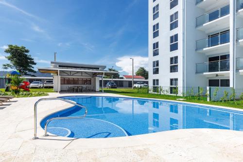 a swimming pool in front of a building at Viva Jaco II in Jacó