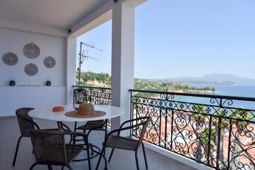a balcony with a table and chairs and a view of the ocean at Ileana Vacation Home in Koroni