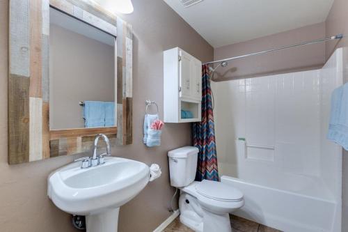 a bathroom with a sink and a toilet and a mirror at Palmen Maricopa in Maricopa