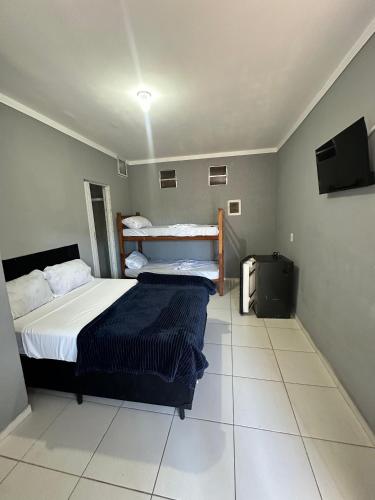 Postel nebo postele na pokoji v ubytování POUSADA OHANA, SUITES ao LADO DO SESC BERTIOGA, e PROXIMO A PRAIA